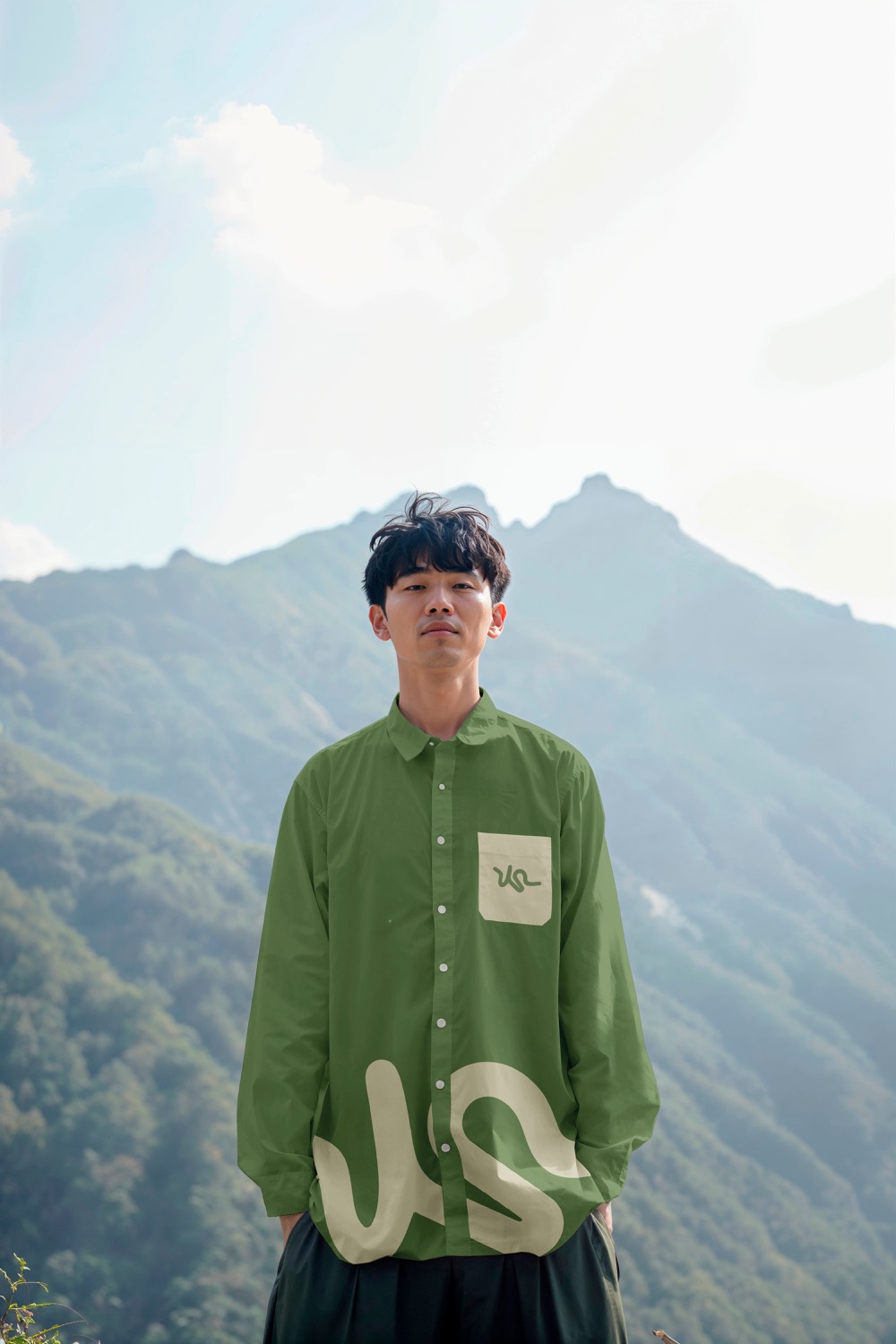 Camisa verde com o traço da Travessia, montanha ao fundo